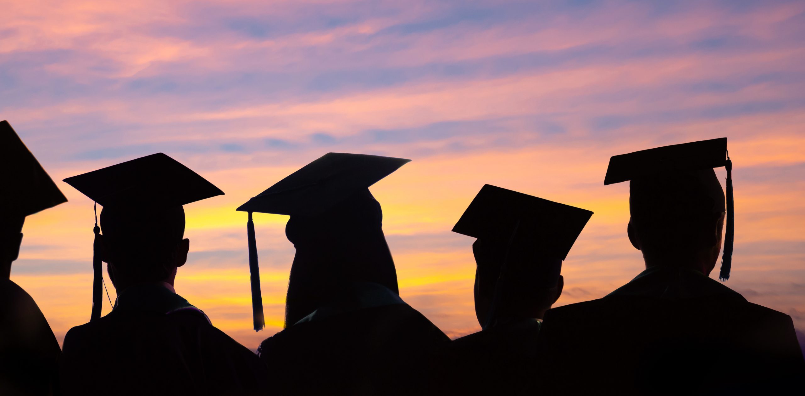 students wearing graduate hat at dark