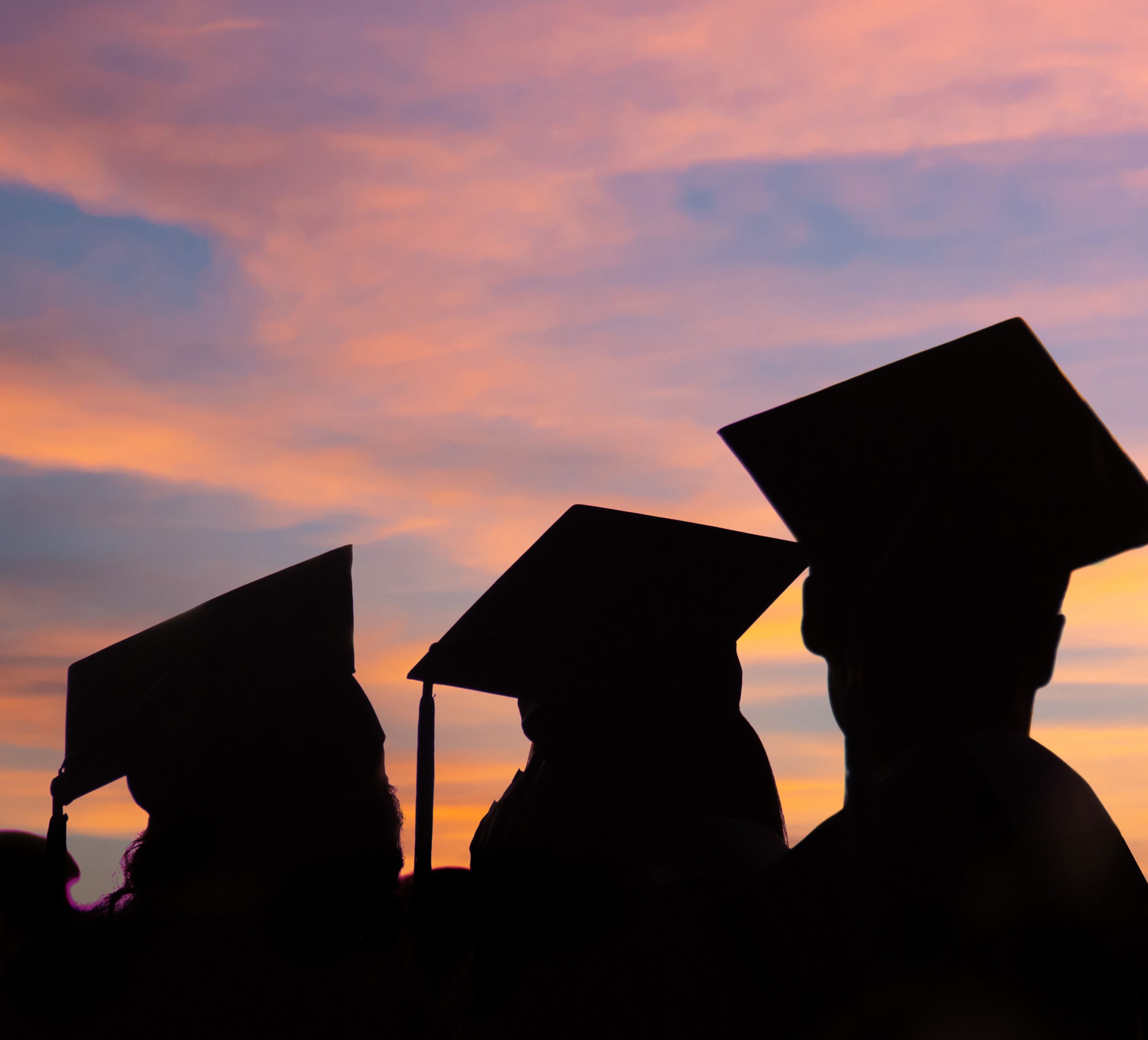students wearing graduate hat at dark