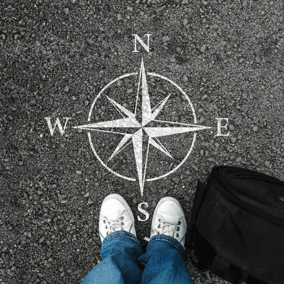 a man with a shoes and backpack is standing next to compass sig