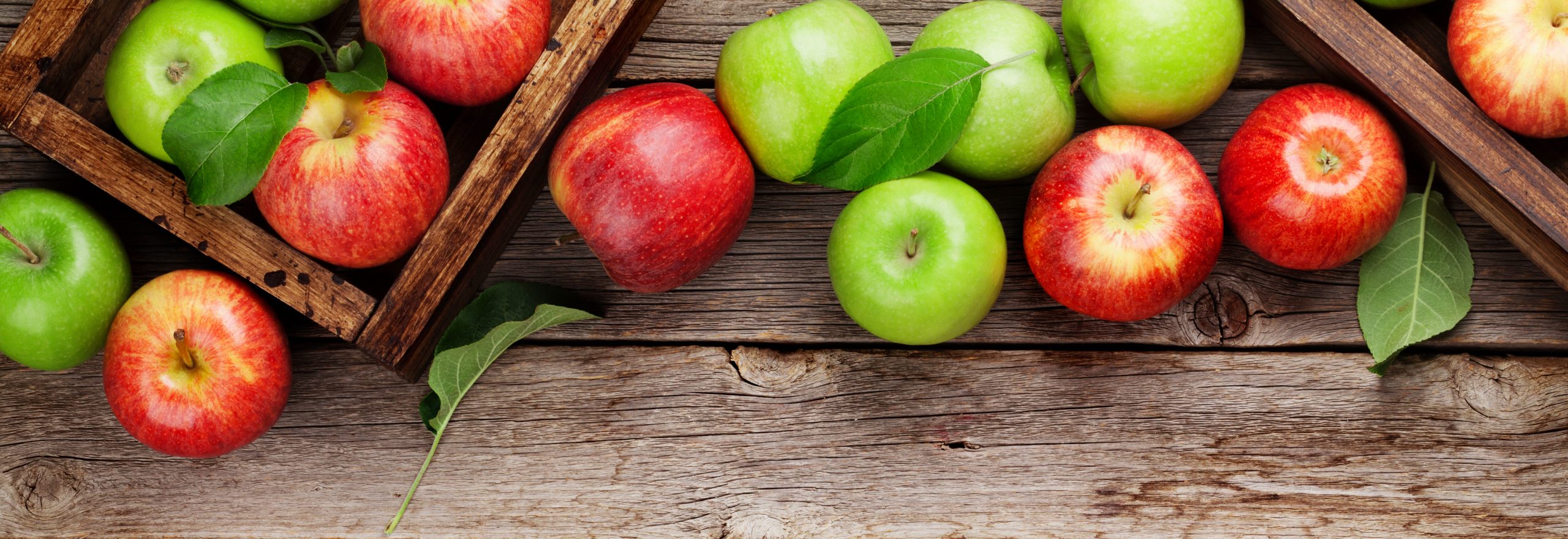 Ripe green and red apples in wooden boxes. Top view flat lay